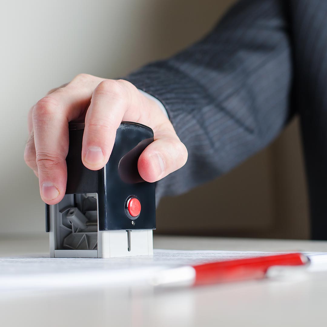 man using a stamp on a document