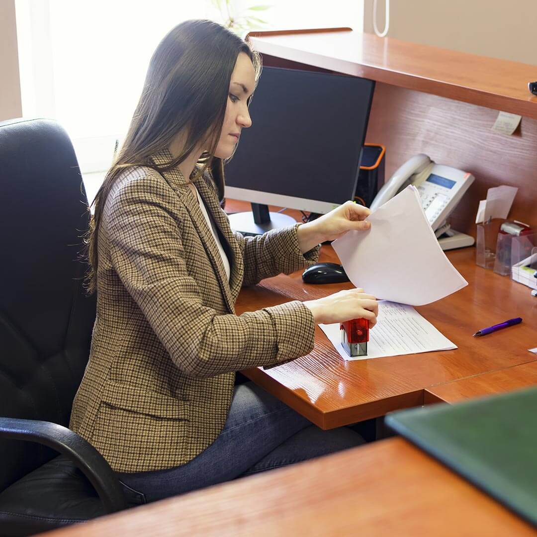 woman using a stamp on a document